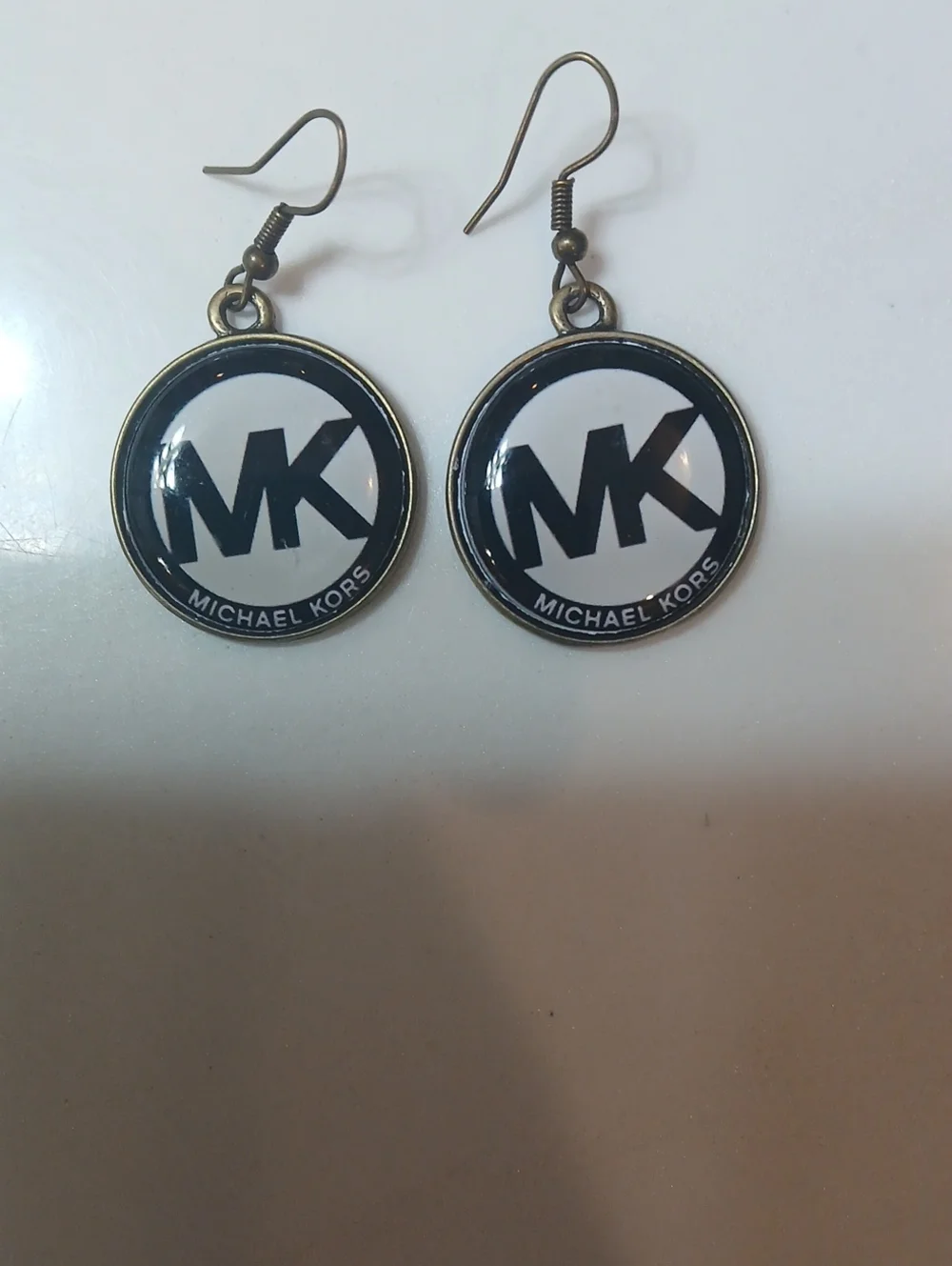 Michael Kors round logo dangle earrings feature the brand's iconic 